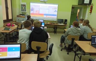 Sala komputerowe. Uczniowie rozwiązują w aplikacji Kahoot! test o Patronie Szkoły.