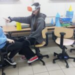 Uczniowie klasy 8 oglądają modele brył, korzystając z okularów VR