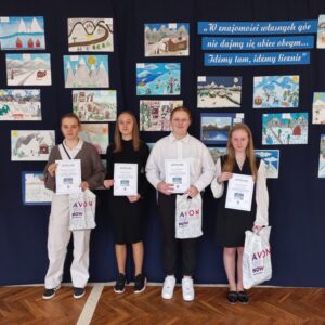 Cztery uczennice nagrodzone w konkursie stoją przed galerią pac konkursowych wykonanych przez uczniów klas I - III.