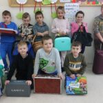Uczniowie klasy 1 z nosidłami: kosz, torby i walizy podróżne, pudełka tekturowe i plastikowe