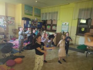 Uczniowie tańczą w sali.