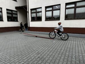 Uczennica Lena Rychlec wjeżdża rowerem na równoważnię.