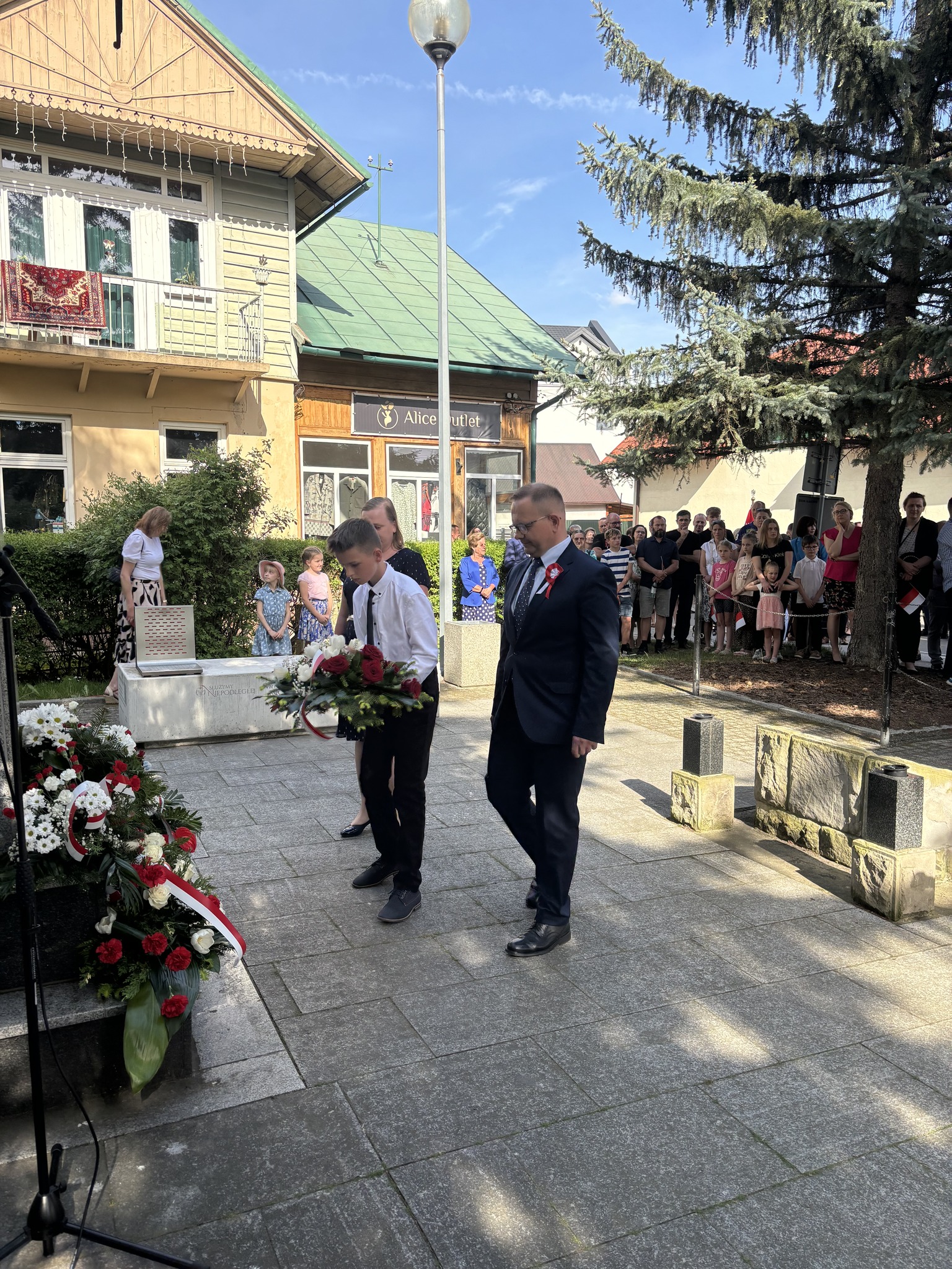 Uczeń naszej szkoły wraz z Dyrektorem i opiekunem SU składają kwiaty pod pomnikiem w Łącku.