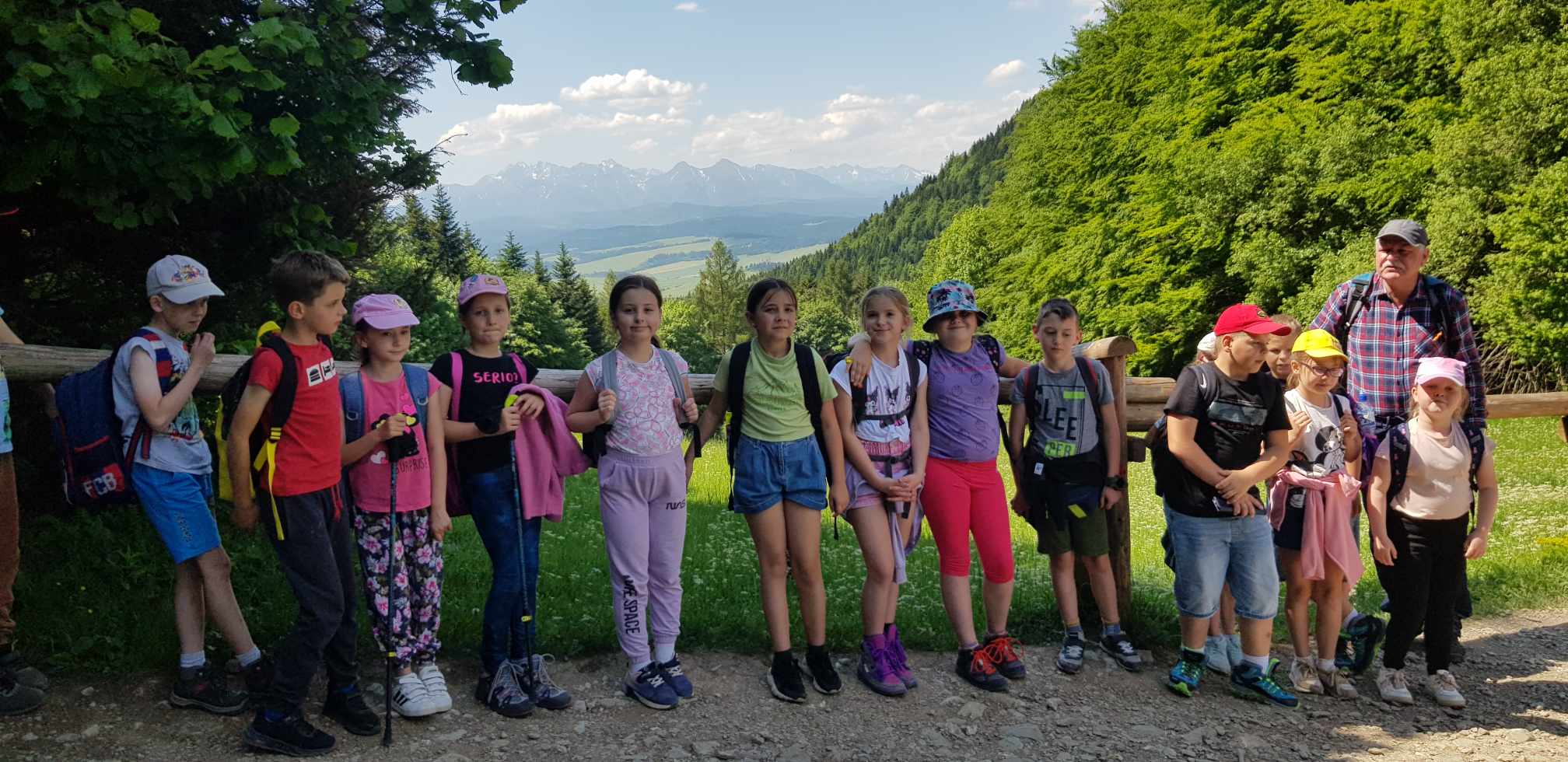 Uczestniczy wycieczki odpoczywają na przełęczy Szopka. W tle widać Tatry.