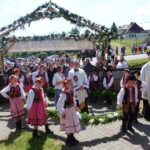 Wprowadzenie Księdza Prymicjanta w wieńcu, który niosą uczniowie - członkowie Zespołu Czarny Potoczek.