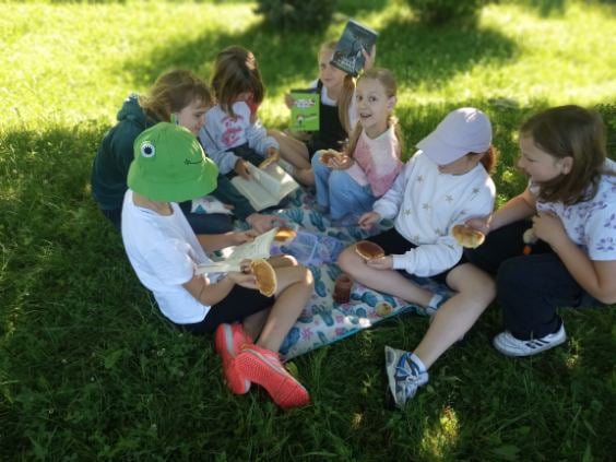 Dzieci czytają książki w plenerze