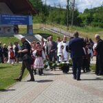 Ksiądz Prymicjant z rodzicami w wieńcu, niesionym przez członków Zespołu Czarny Potoczek wyprowadzany po Mszy Św. Prymicyjnej