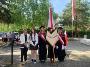Czterech uczniów i nauczycielka podczas gminnych obchodów Święta Konstytucji