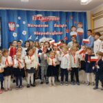 Występ dzieci przedszkolnych -dzieci machają chorągiewkami