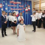 Występ uczniów - dziewczynka-Polska symbolicznie krępowana łańcuchem (z papieru) przez dwóch uczniów i jedną uczennicę-zaborców