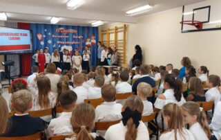 Występ uczniów - trzy uczennice recytują wiersz - zdjęcie zza publiczności