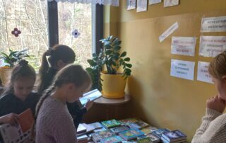 Uczniowie, przeglądający książki.