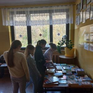 Uczniowie przy stoisku z książkami.