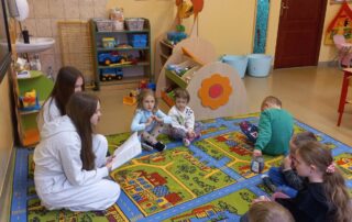 Uczniowie kl. VIII podczas czytania dzieciom w oddziale przedszkolnym.