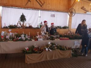 Dwie uczennice przy stoisku szkolnym podczas kiermaszu