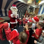 Mikołaj i dwoje elfów pośród dzieci