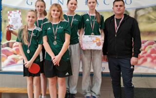 Dziewczęta z medalami i dyplomami wraz z nauczycielem wych. fiz.