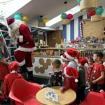 Mikołaj schodzi po drabinie do zgromadzonych dzieci