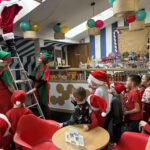 Mikołaj schodzi po drabinie do zgromadzonych dzieci