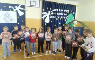 Uczniowie klasy I podczas otrzymywania książki Wnuczka Antykwariusza