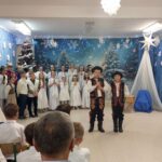 Dwaj chłopcy w strojach lachowskich rozpoczynają jasełka