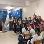 Dzieci grają na różnych instrumentach: akordeonie (3 chłopców), skrzypcach (3 dziewczyny), flecie (1 dziewczyna)