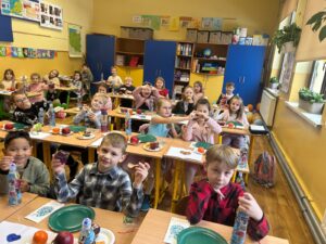 Na zdjęciu widać uśmiechnięte dzieci bawiące się i tańczące na zabawie andrzejkowej.
