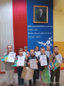 Na zdjęciu widać uśmiechniętych i dumnych uczniów którzy brali udział w konkursie. Dumnie pokazując otrzymane dyplomy i nagrody.