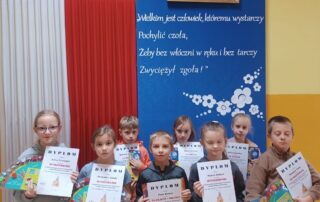 Na zdjęciu widać uśmiechniętych i dumnych uczniów którzy brali udział w konkursie. Dumnie pokazując otrzymane dyplomy i nagrody.