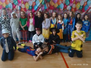 Na zdjęciach widać dzieci w pięknych kolorowych karnawałowych strojach. Dzieci tańczą do muzyki na sali gimnastycznej