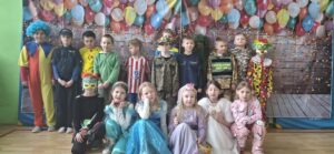 Na zdjęciach widać dzieci w pięknych kolorowych karnawałowych strojach. Dzieci tańczą do muzyki na sali gimnastycznej